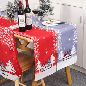 Close-up of red and grey Christmas table runners with gnome patterns and dining set