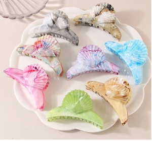 Detail of elegant marbled shell hair claws in various patterns on a white lace plate