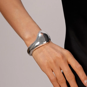 Makroaufnahme der silbernen, asymmetrischen Manschettenarmspange mit Metallic-Finish