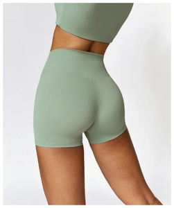 Dettaglio macro dei pantaloncini da yoga verde salvia a vita alta con cucitura a V sul retro