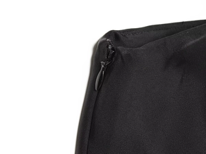 Detailed macro view of the invisible zipper closure on this black asymmetric lace top fabric