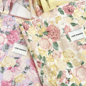 Macro shot of floral canvas tote bag fabric with twill texture and Love Sozakka label