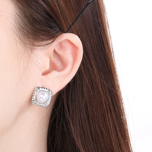 Gros plan détaillé de boucles d'oreilles perles carrées serties de zircons sur base argent