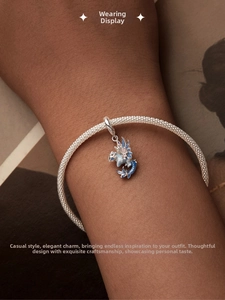 Détail du bracelet en maille d'argent S925 avec pendentif dragon en émail bleu sur le poignet
