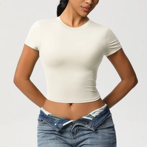 Close-up of white slim-fit crop top yoga shirt with crew neck and elastic fabric