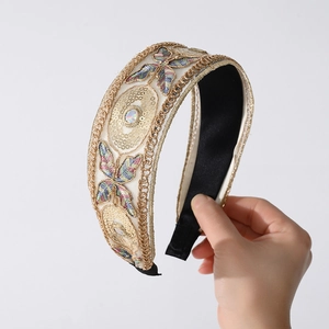 Detail of lace headband with butterfly embroidery, gold sequins and a center gemstone