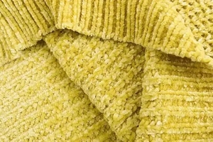 Detailed close-up of textured chenille fabric in vibrant lime green with soft cable knit