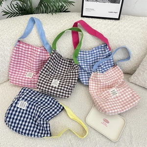Detailed top view of canvas tote bags featuring vibrant checkered patterns and color-contrast straps