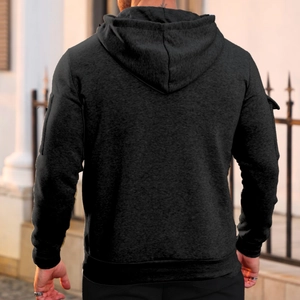 Rear view of black men's hooded sweatshirt with sleeve zipper pocket in outdoor setting