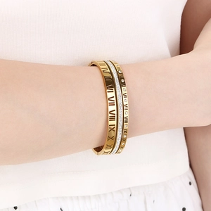 Detail of three-row gold stainless steel bangle with Roman numerals and pavé crystals