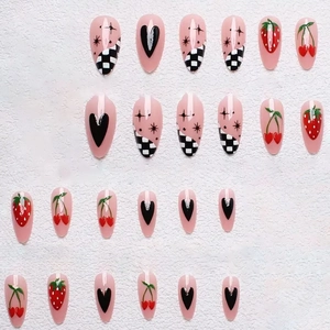 Long almond press-on nails featuring strawberry, cherry, heart, and checkerboard patterns