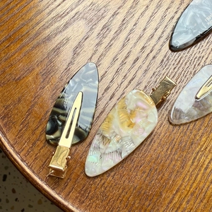 Detailed view of handmade acetate marble hair clips with elegant gold metal fasteners