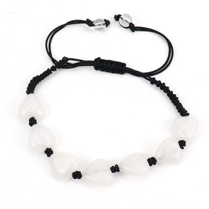 Detail of hand-woven black cord bracelet featuring seven heart-shaped white stone beads