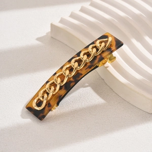 Chic tortoiseshell hair clip with golden chain link decor on a clean white background