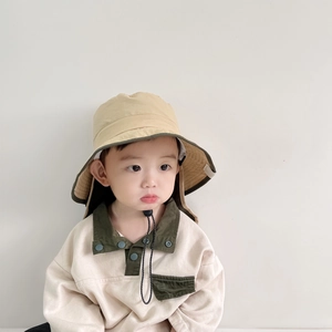 Detail of baby sun hat with windproof strap and matching beige long sleeve polo shirt
