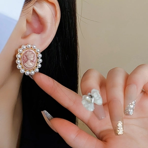 Gros plan de boucles d'oreilles camée vintage avec bordure en perles et style rétro français