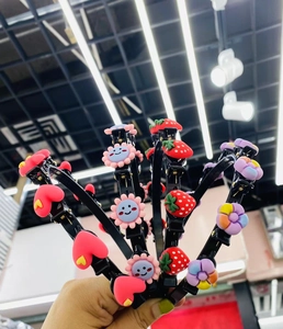 Close-up of colorful cartoon hairbands with clips featuring strawberry and flower designs