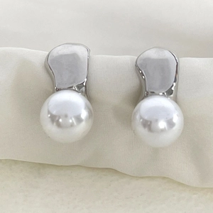Boucles d'oreilles élégantes en métal irrégulier avec perles sur fond de soie