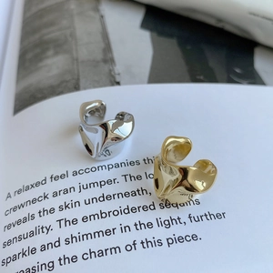 Macro shot of irregular lava texture rings in gold and silver finish on a stylish book