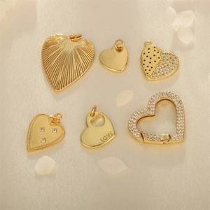 Set of 6 gold plated heart charms with crystals and love engraving on soft fabric