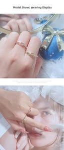 Detail showing two hollow intertwined rings in rose gold and gold with sparkling zircons
