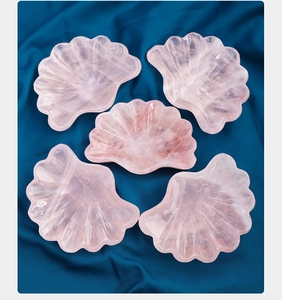 Dettaglio di ciotole a conchiglia in quarzo rosa su un tessuto di seta blu scuro