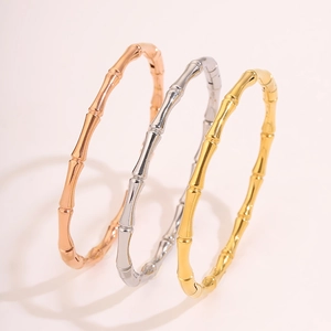Dettaglio dei bracciali in acciaio al titanio a forma di bambù, oro, oro rosa e argento