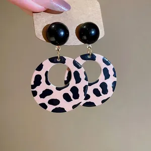 Retro leopard print circular drop earrings with black studs on vintage display card