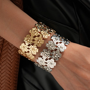 Polished gold and silver layered open cuff bracelets with cutout floral daisy patterns