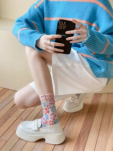 Detailed shot of retro floral socks paired with white platform loafers for a vintage look