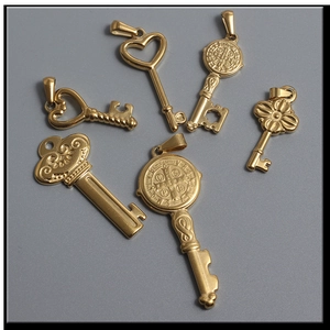 Detailed view of six assorted 18K gold-plated stainless steel key pendants with ornate motifs