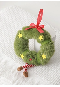 Dettaglio macro di una ghirlanda natalizia in peluche verde con stelle e fiocco rosso