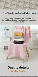 Detail of soft waffle weave cotton towels in various pastel colors on a wooden chair
