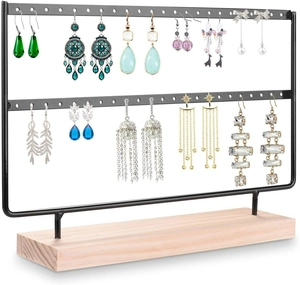 Detail of earring display stand with black metal racks and a sturdy wooden base