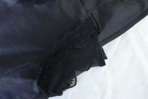 Close-up of black lace trim and silky satin fabric texture on the slit bodycon dress
