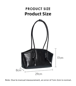 Detailed view of black glossy shoulder bag with dimensions 29cm x 17cm x 8cm