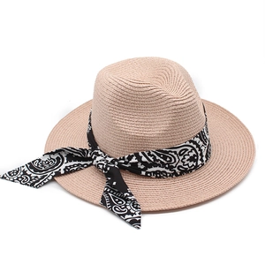 Classic light beige straw fedora with black paisley ribbon on a white background