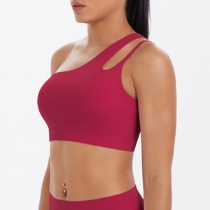 Detail of dark red one-shoulder sports bra with asymmetrical cut-out design and soft fabric