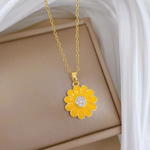 Macro view of sunflower pendant with yellow enamel and sparkling crystals on gold chain
