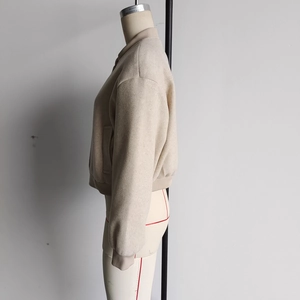 Close-up of beige tweed bomber jacket texture and side profile on a mannequin