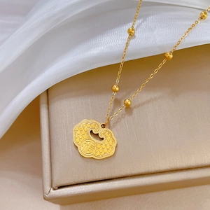 Close-up of gold titanium steel Fu character lock pendant on a beaded necklace chain