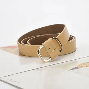 Minimalist light khaki leather belt for women featuring a rounded golden D-ring metal buckle