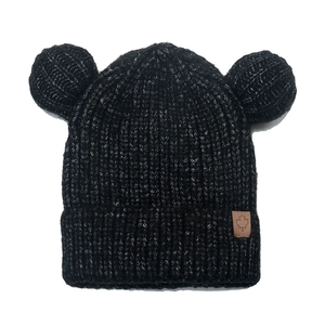 Detailed knit texture of black baby hat with bear ears and maple leaf leather patch