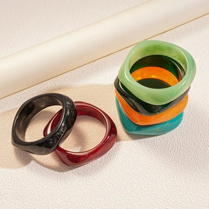 Minimalist geometric resin bracelets in marble and vibrant colors on artistic props