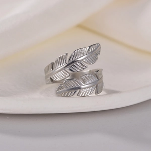 Adjustable silver feather ring in titanium steel with detailed texture on white tray