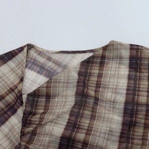 Close-up of brown plaid mesh top featuring retro knit texture and diagonal neckline stitching