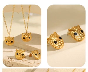 Detail showing golden owl pendant necklace and earrings with hammered texture and black stones