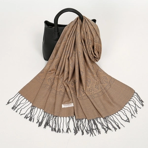 Dettaglio della sciarpa pashmina jacquard marrone con frange drappeggiata su borsa