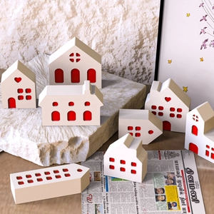 Detailed view of white ceramic house molds with hollow red interior for DIY crafts
