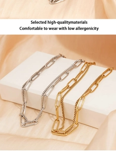 Detail view of gold and silver double-layer box chain bracelet on a luxury backdrop